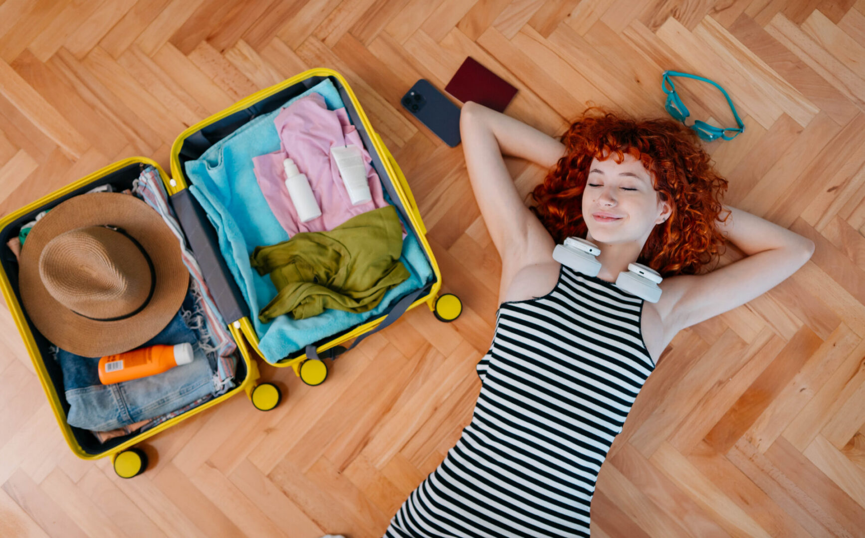Traveler resting beside packed suitcase