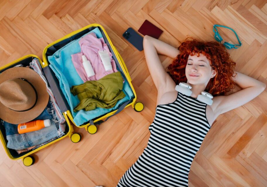 Traveler resting beside packed suitcase