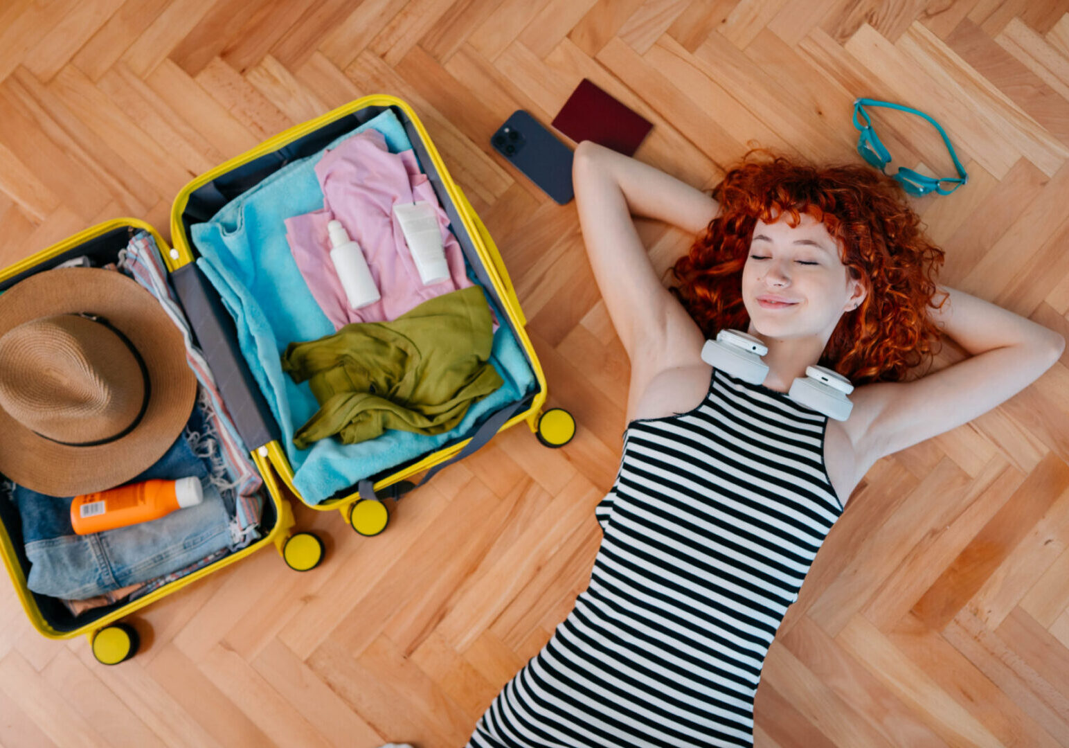 Traveler resting beside packed suitcase